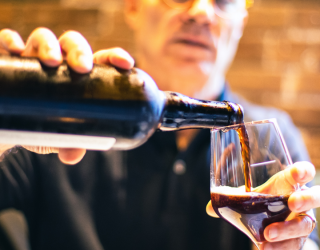 Man pouring stout into a glass from a bottle