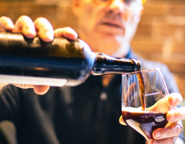 Man pouring stout into a glass from a bottle