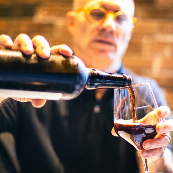 Man pouring stout into a glass from a bottle
