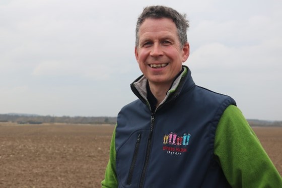 An image of Bill Smith in a field discussing sustainable farming